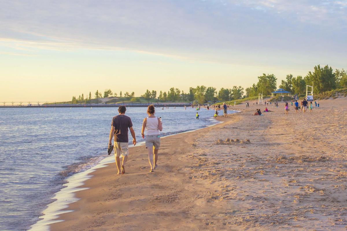 Two people walking on the beach at Silver Beach. 