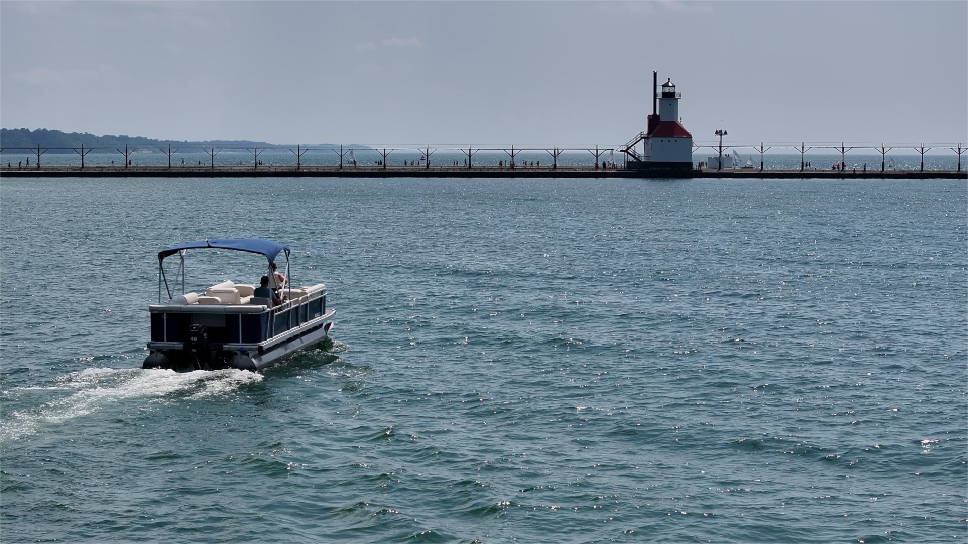 Pontoon boat driving on Lake Michigan near the St. Joseph lighthouse