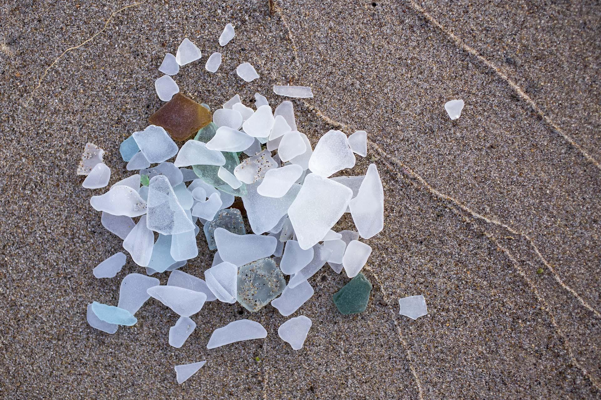 A pile of colorful beach glass on the sand.