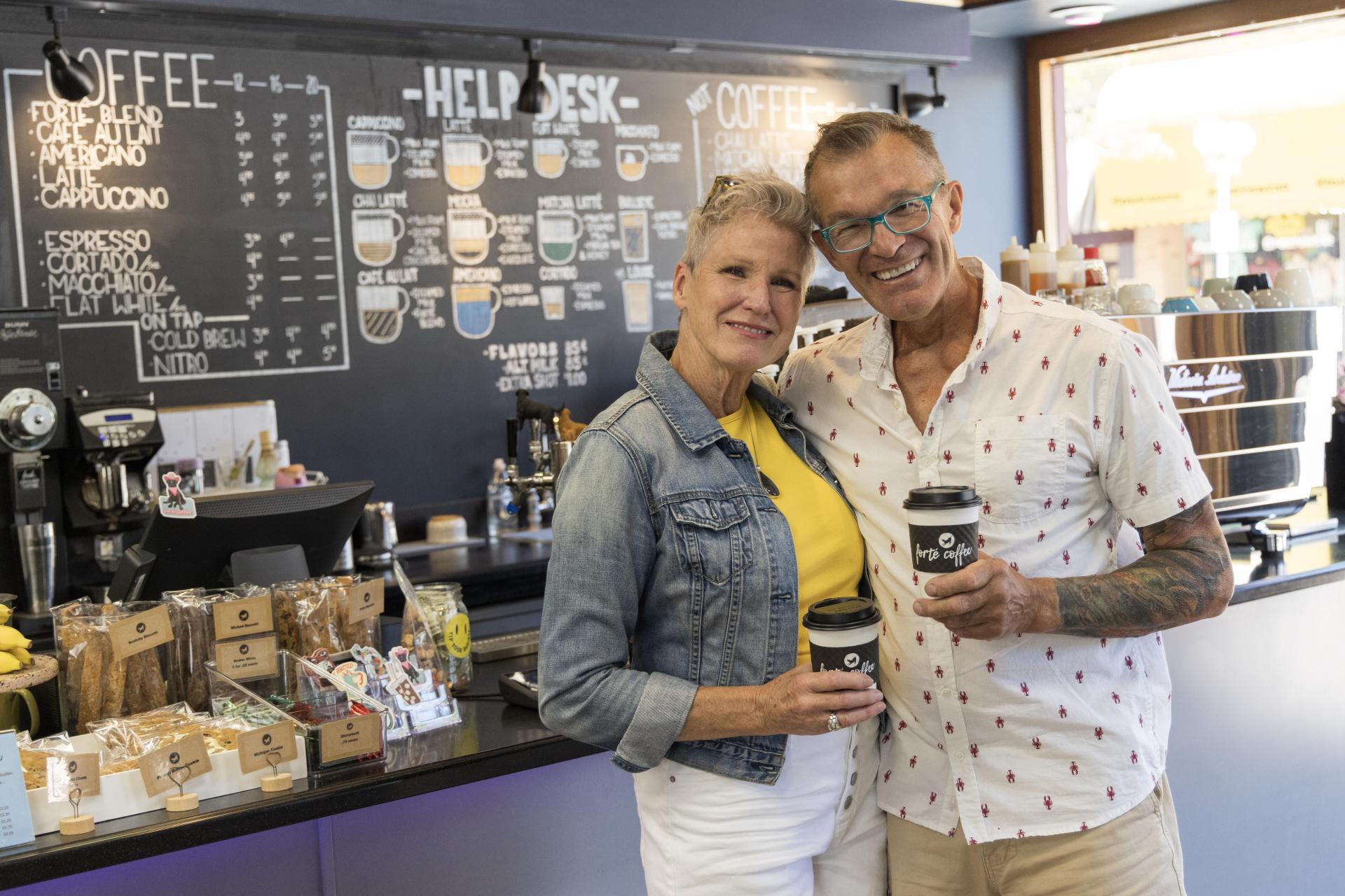 A couple smiling in Forte Coffee after receiving their coffee.