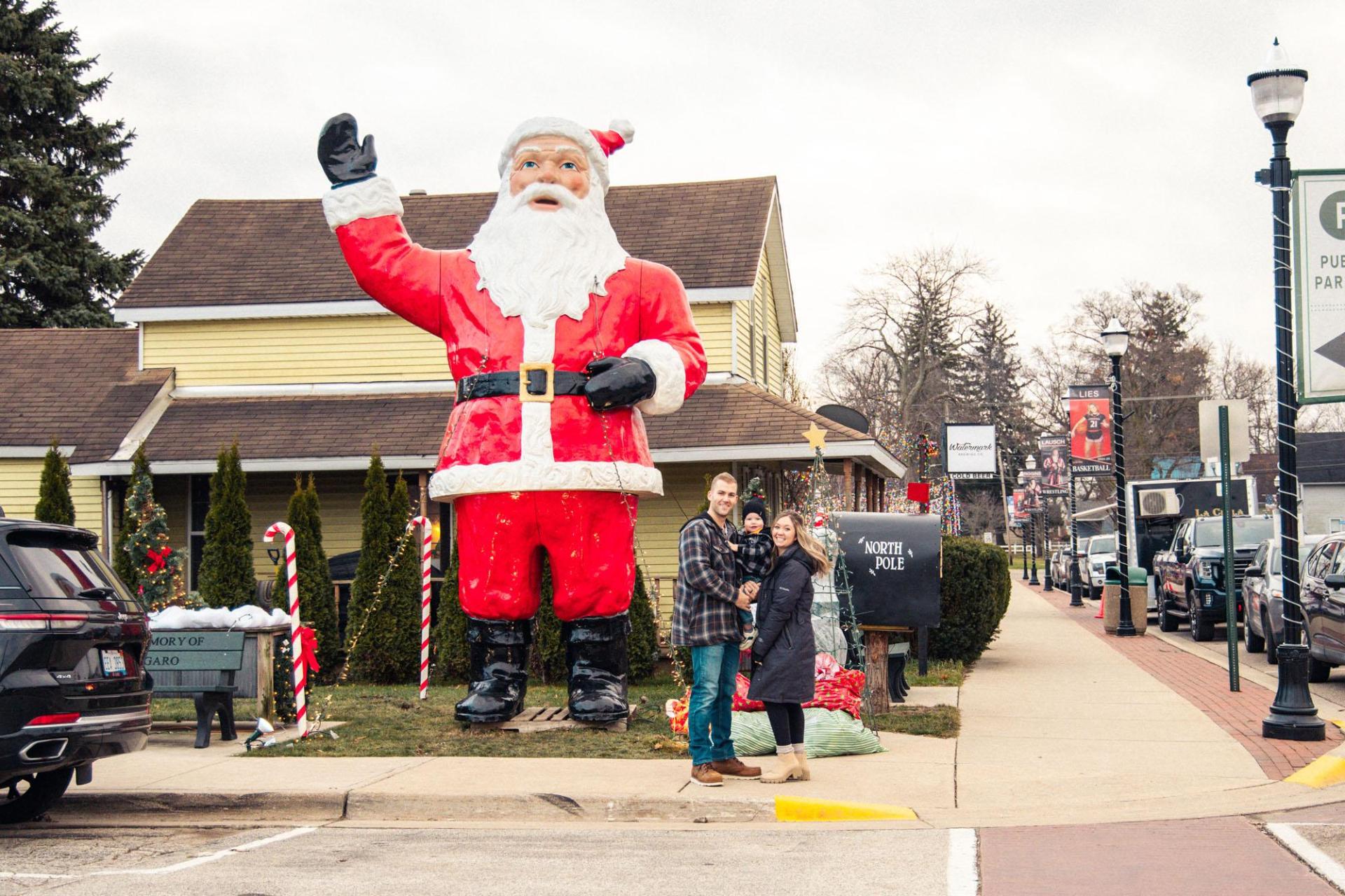 A family poses for a photo in front of a large Santa statue in Stevensville, MI.