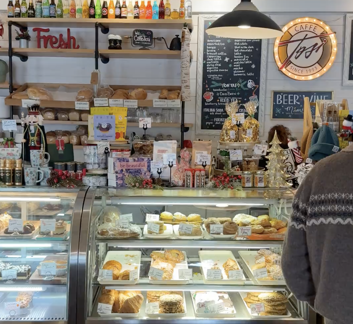 Colorful interior of Café Tosi, featuring the menu and a pastry display case.